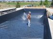 man supervising the laying vinyl liner