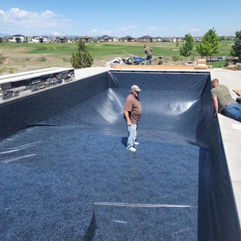 man supervising the laying vinyl liner